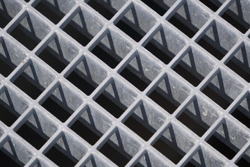 square geometry of the iron plates, sturdy bars. play of light and shadow, screensaver, background. diagonal lattice background from metal. Gray tint.