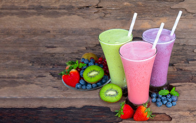 Strawberry kiwi and blueberry  smoothies colorful fruit juice milkshake blend beverage healthy high protein the taste yummy In glass drink episode morning on wood background.