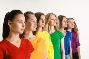 Young women weared in LGBT flag colors isolated on white background. Caucasian female models in bright shirts. Look happy, smiling. Trust LGBT pride, human rights, freedom of choice concept.