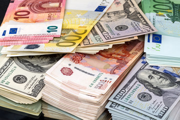 Bundles  of money in three currencies