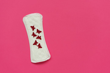 Sanitary napkins or pad with red butterfly glitters on pink background. Female intimate hygiene...