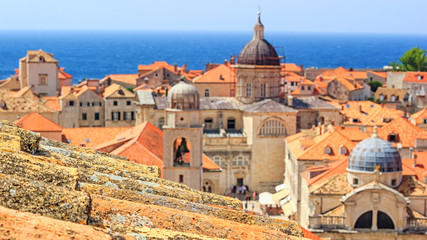 Fototapeta premium Summer mediterranean cityscape - view of the old roof on the background of the Old Town of Dubrovnik on the Adriatic coast of Croatia, closeup