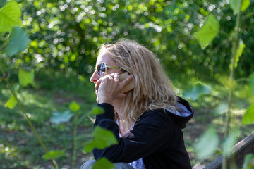 Young woman in the forest speak on the phone