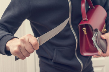 Thief with knife, stealing valuable things, close up