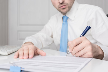 Man working in the office, documents on his desk, cropped image, closeup