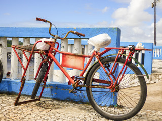 Fototapeta premium Bicycle with a plastic bag protecting the saddle parked on the promenade of Itapissuma - Pernambuco, Brazil
