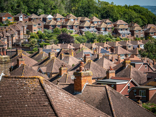 Suburban Rooftops. A view over the a post-war 1950's English housing estate on the fringes of Eastbourne backed by green belt ancient woodland.