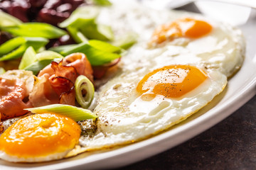 Fototapeta na wymiar English Breakfast with eggs, bacon, beans and iyoung onion in white plate