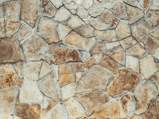 Imitation of a wild stone. Wall decorated with ocher stone tiles. The effect of the fortress.