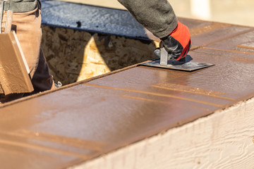 Construction Worker Using Stainless Steel Edger On Wet Cement Forming Coping Around New Pool