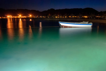 A small boat illuminated at night