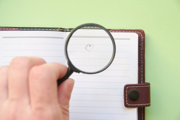 The concept of finding love. Heart under a magnifying glass.