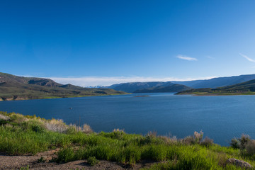 Fototapeta na wymiar Landscape of Blue Mesa Reservoir with greenery and hills in the background near Gunnison, Colorado