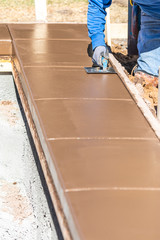 Construction Worker Using Stainless Steel Edger On Wet Cement Forming Coping Around New Pool