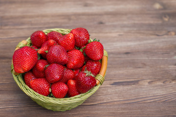 strawberries in a basket on a wooden background