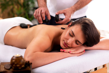 Obraz na płótnie Canvas Pretty girl having a stone massage therapy