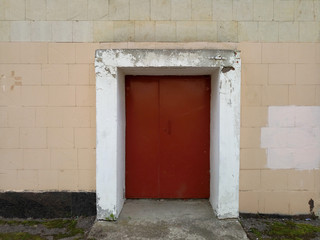 old red door on the facade of the building