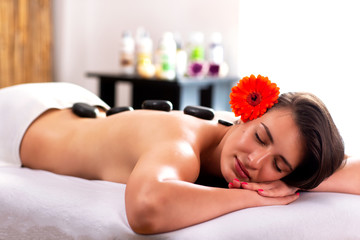 Obraz na płótnie Canvas Hot stone massage therapy in beauty salon