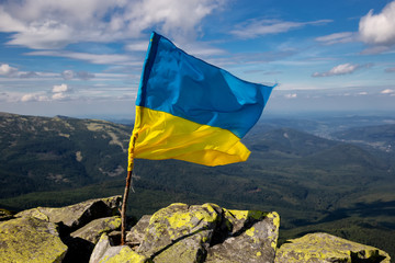 The flag of Ukraine on top of the Carpathian mountains. Beautiful mountain landscape