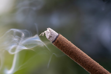 Incense stick burning with smoke, closeup . Island Bali, Ubud, Indonesia