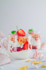 Yogurt dessert in glass glasses with strawberries on a white background