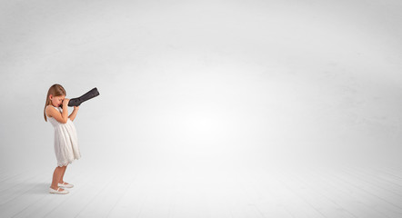 Cute little girl looking through spyglass to an empty space