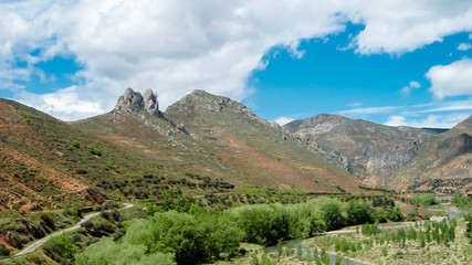 Paisaje montañoso con un cielo azul y nubes blancas