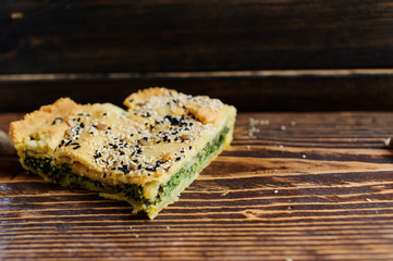 Homemade spinach french pie on a white wooden board