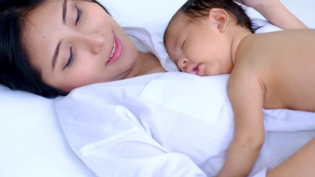 Closeup young asian mother sleeping her baby lullabies
