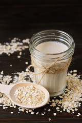 Glass of vegan oat milk and Oat on a table, space for text.