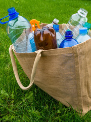 Fototapeta premium Ecological burlap bag and plastic bottles inside. Zero waste shopping concept.