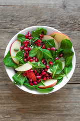 Spinach, apple salad with pomegranate seeds