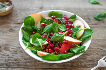 Spinach, apple salad with pomegranate seeds