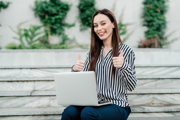 woman using laptop outdoors in the city