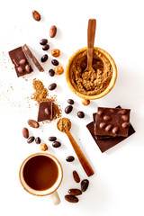 Chocolate bars and nuts on white table background top view