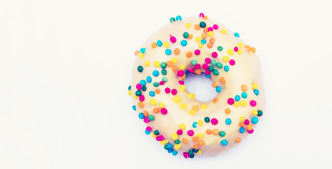 Yellow donut with bright sprinkles on a white background, copy space, advertising