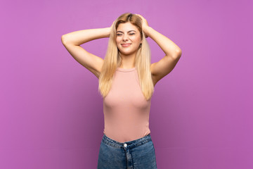 Teenager girl over isolated purple background frustrated and takes hands on head