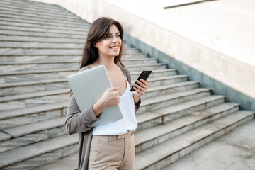 Fototapeta premium woman with laptop and phone in the city