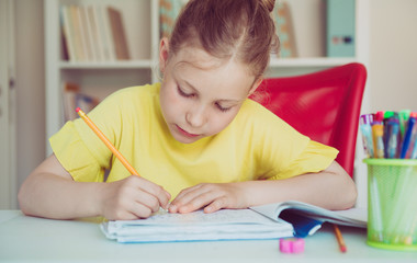 Portrait of pretty school girl are studying at classroom at the table