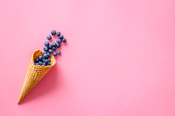 Summer breakfast with fresh berries in waffle cones on pink background top view mockup