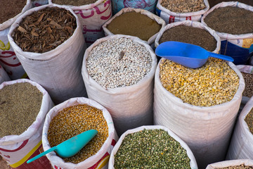 Morocco, Tinerhir. Bags or dried beans, legumes, cinnamon bark, and rice for sale in a market stall.