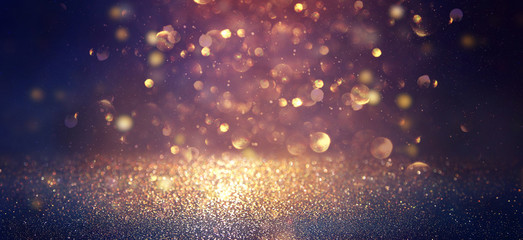 blackground of abstract glitter lights. blue, gold and black. de focused. banner