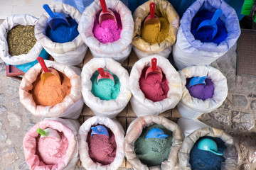 Morocco, Chefchaouen or Chaouen is most noted for its small narrow streets and neighborhoods painted in variety of vivid blue colors. Bags of colorful paint pigments.