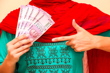 Female hands holding brand new indian 2000 rupees banknotes.