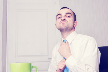 Portrait, narcissistic businessman, he straightens his tie, close up, toned