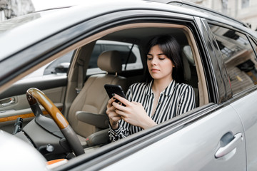 woman in car uses phone