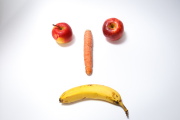 Sad smiling fruit face on white background