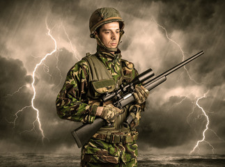 Armed soldier standing in rainy obscure weather