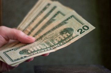Woman Holding Twenty Dollar Bills on a Black Background