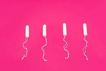 Tampons on a red background, close up, top view, menstrual period concept